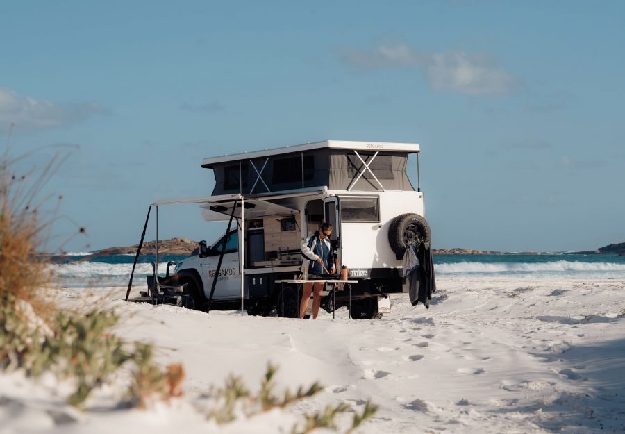 Een vrouw is een maaltijd aan het voorbereiden in een prachtige omgeving op het strand