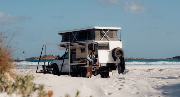 Een vrouw is een maaltijd aan het voorbereiden in een prachtige omgeving op het strand