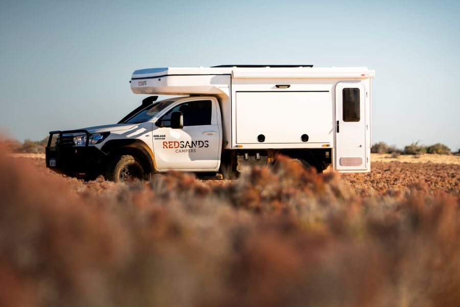Een tussenstop met de camper in een omgeving met zandgrond en struiken