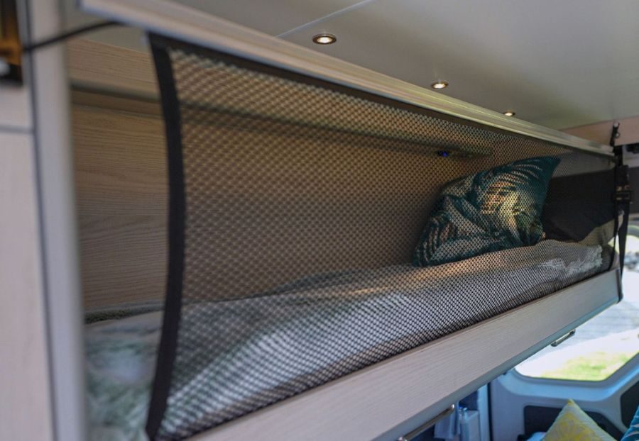 Het bed boven de zithoek achterin de Wendekreisen Koru 3 Freedom is opgemaakt