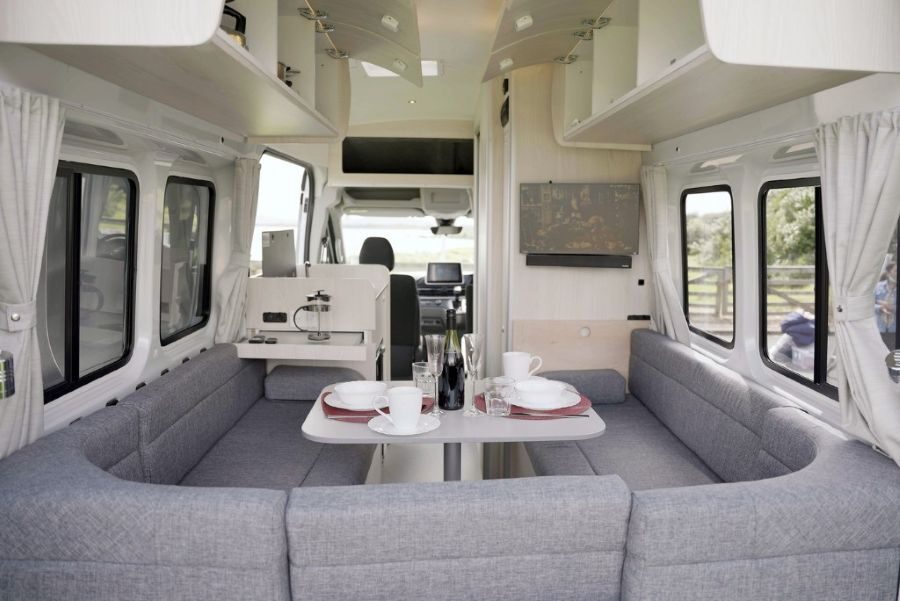 De tafel van de zithoek achterin de Wendekreisen Koru Star 2 Freedom is gedekt en er is zicht op het interieur vanuit de open achterdeuren
