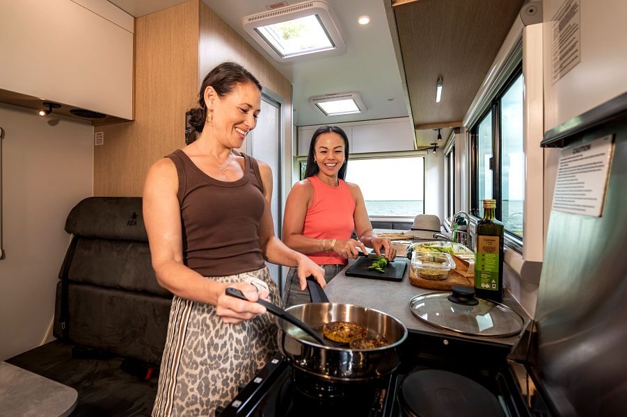 Twee vrouwen zijn aan hete koken in de keuken van de Maui River camper