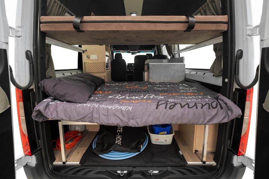 Het tweepersoonsbed van de Mighty Highball camper vanuit de achterkant gezien