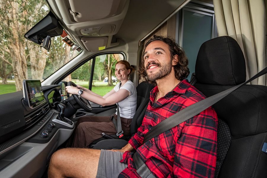Een koppel is aan het rijden in de Mighty Highball camper