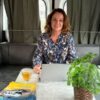 Karin Kramer zit in de camper met kop thee en laptop