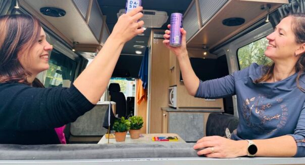 Carolien en Leonore van Campers Down Under proosten in de Maui Ultima met de achterdeur open