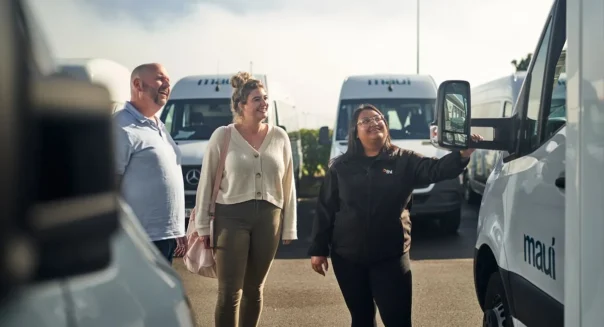 Man en vrouw halen camper op in Nieuw-Zeeland en krijgen uitleg van een medewerker