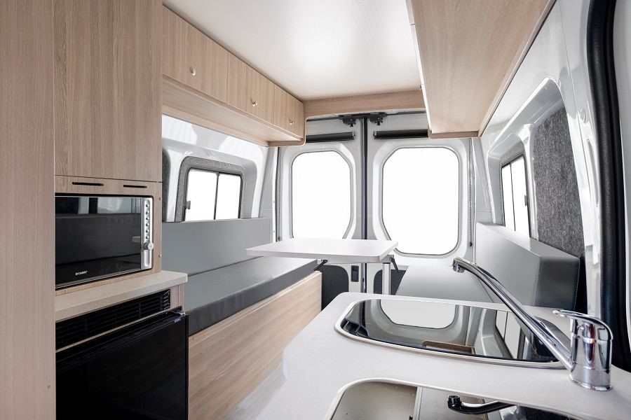 Het interieur van de Apollo Hitop camper in Australië met een zithoek achterin