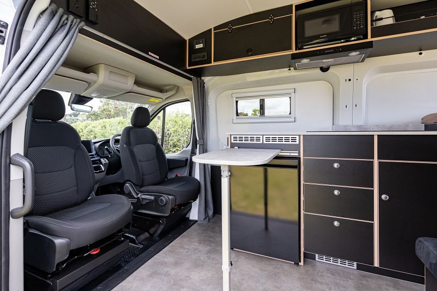 De draaibare bestuurdersstoelen met tafel in de Apollo Hitop camper in Nieuw-Zeeland