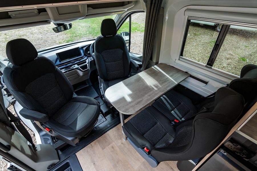 De draaibare bestuurdersstoelen in de Mighty Double Down camper met tafel en twee extra zitplaatsen