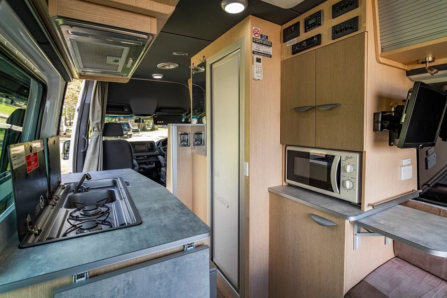 Het interieur met keuken vanaf de achterkant kijkend naar voren in de Mighty Deuce Plus camper