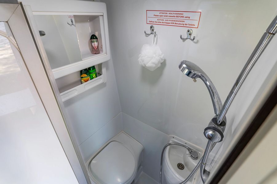 De badkamer met toilet, wasbak en douche in de Mighty Deuce Plus camper