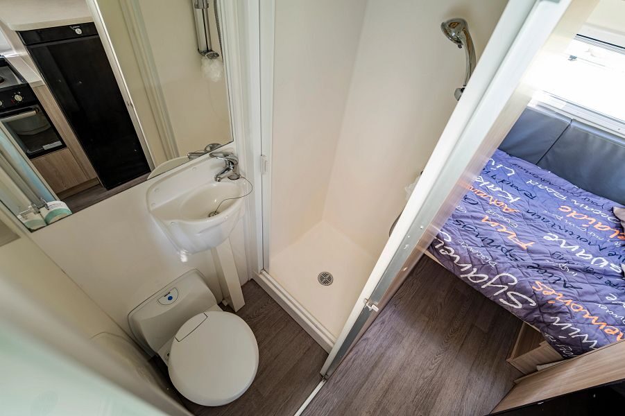 De badkamer met toilet, wastafel en douchecabine in de Mighty Big Six camper