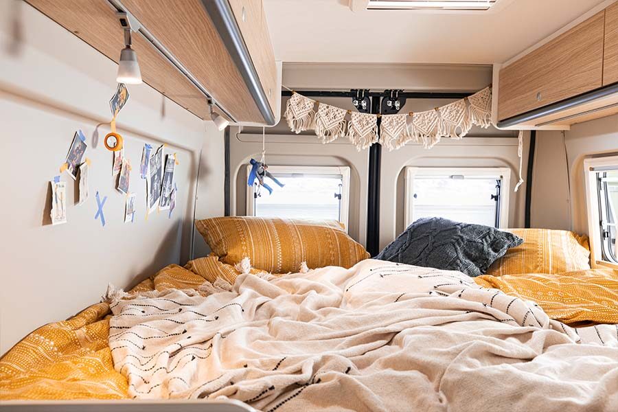 Het tweepersoonsbed achterin de McRent Urban Plus camper met kastruimte erboven