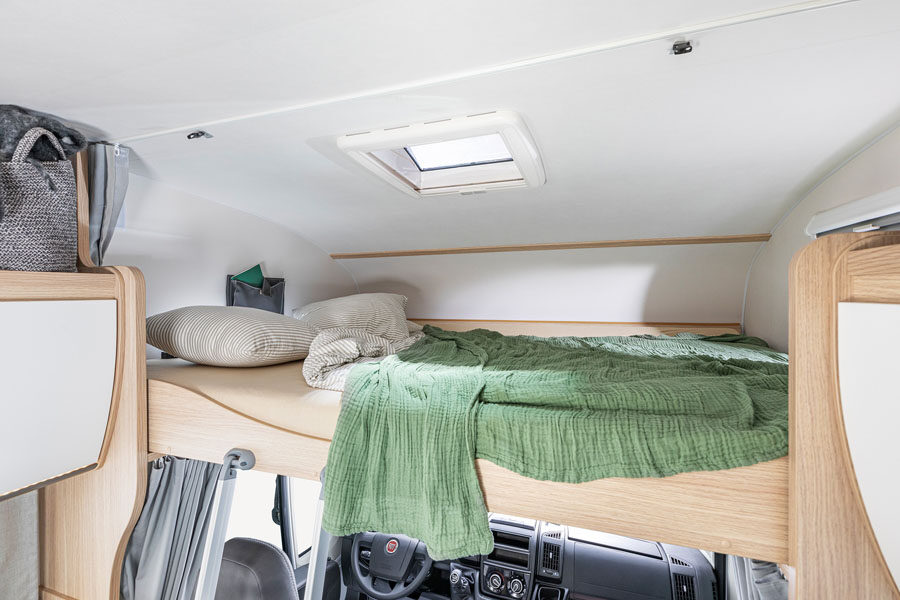 Het tweepersoonsbed in de alkoof boven de cabine in de McRent Family Plus camper