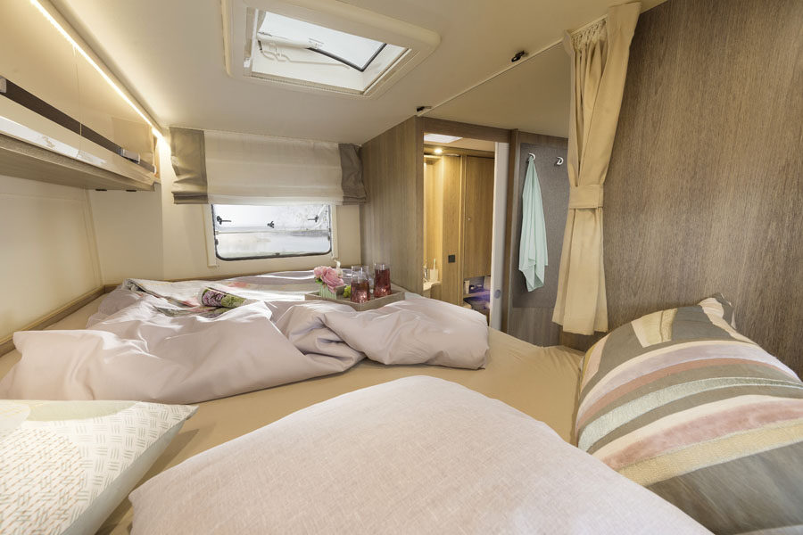 Het eenpersoonsbed boven in de stapelbed aan de achterkant van de McRent Family Plus camper