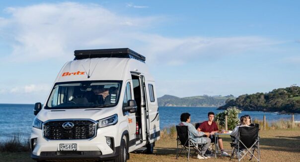 Toeristen zitten in campingstoelen bij Britz Voyager op het Noordereiland