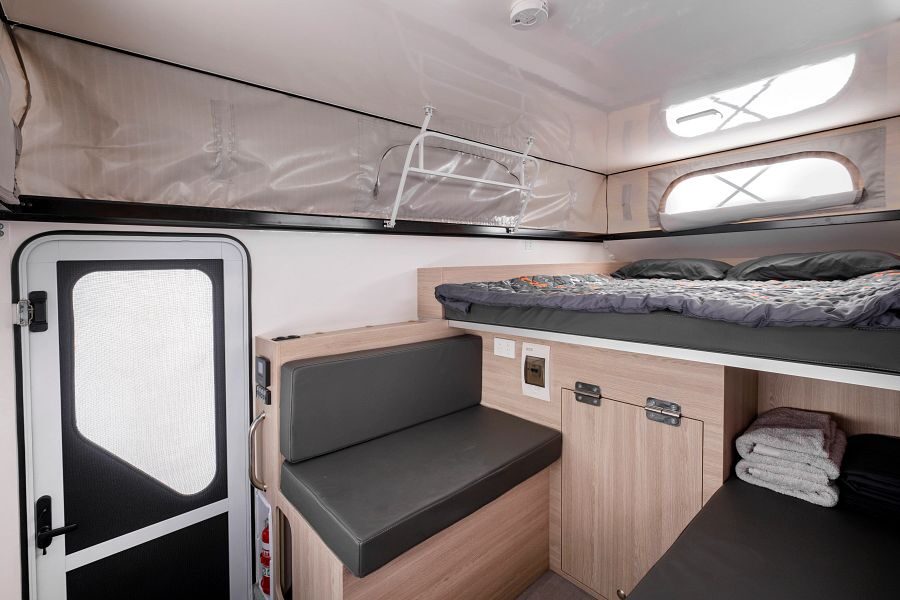 Het interieur met bank en bed van de Mighty 4WD in Australië