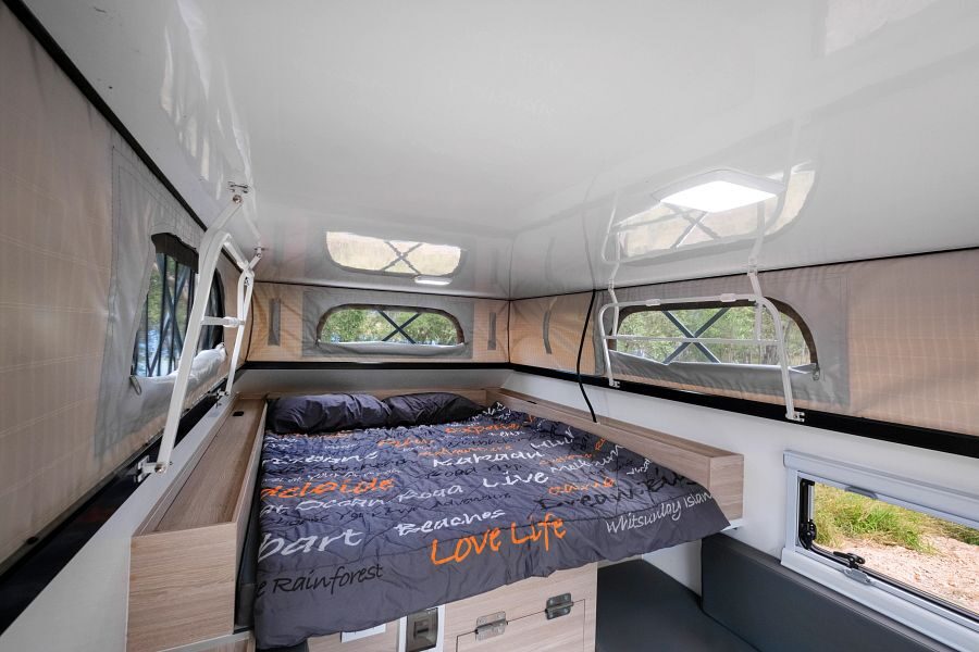 Het tweepersoonsbed met een verlengd dak in de Mighty 4WD camper in Australië