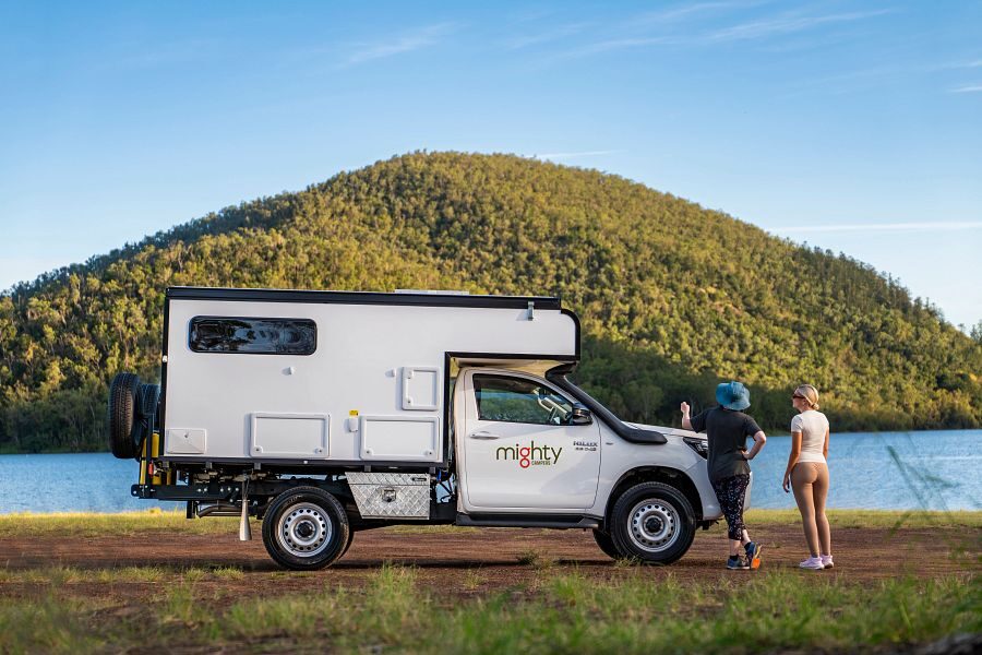 De zijkant van de geparkeerde Mighty 4WD camper met twee personen kijkend naar het uitzicht in Australië