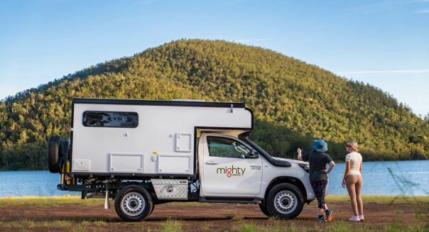 De zijkant van de geparkeerde Mighty 4WD camper met twee personen kijkend naar het uitzicht in Australië