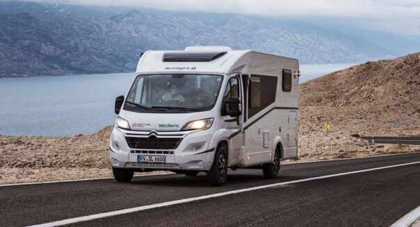 Een stel rijdt in de McRent Compact Plus camper over een geasfalteerde bergweg in Nieuw-Zeeland