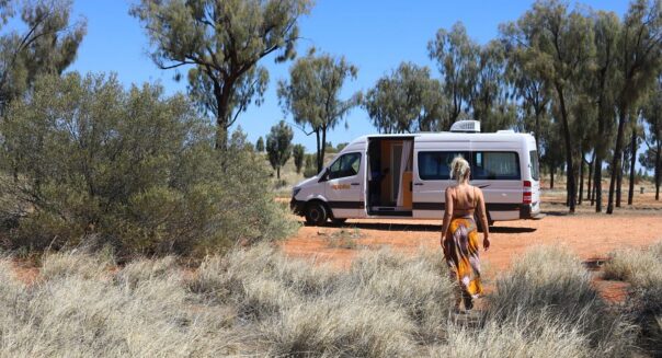 De Apollo Euro Tourer staat geparkeerd op rode gravel en een vrouw loopt ernaartoe