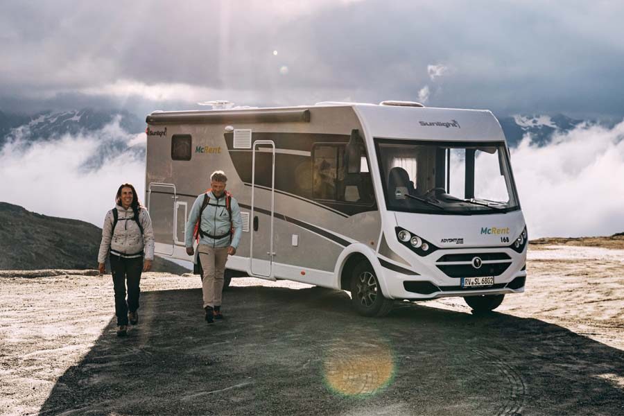 Een stel heeft de McRent Comfort Luxury geparkeerd en loopt weg