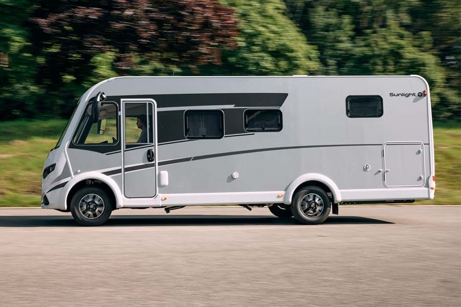 Een man rijdt in de McRent Comfort Luxury vanaf de zijkant gezien