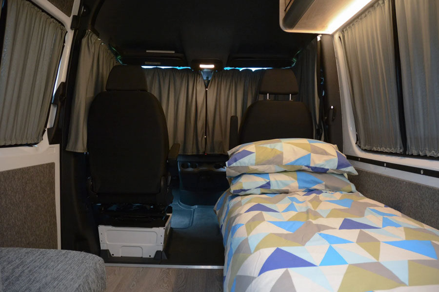 Opgemaakt eenpersoonsbed die je kunt ombouwen tot tweepersoonsbed in de Pacific Horizon 2 plus 1 camper