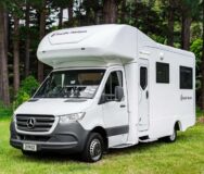 De voor- en zijkant van de Pacific Horizon Gem 4 camper geparkeerd op een grasveld in Nieuw-Zeeland