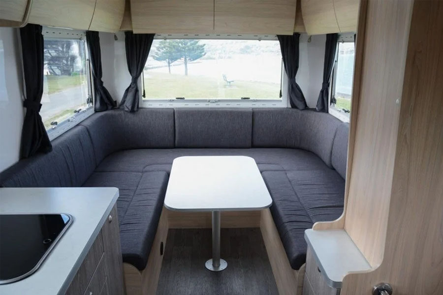 De zithoek met tafel achterin de Pacific Horizon Max 4 camper