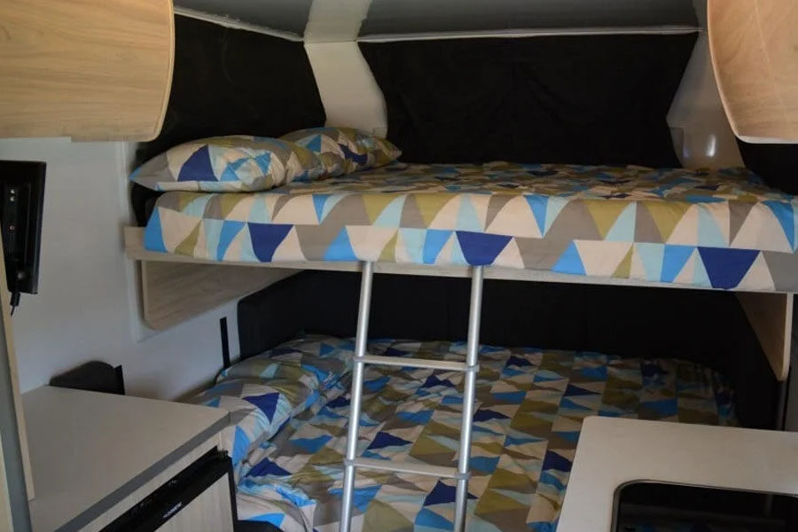 De twee tweepersoonsbedden boven elkaar achterin de Pacific Horizon Sam 6 camper