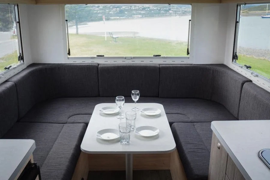 De ruimte zithoek met tafel achterin de Pacific Horizon Sam 6 camper