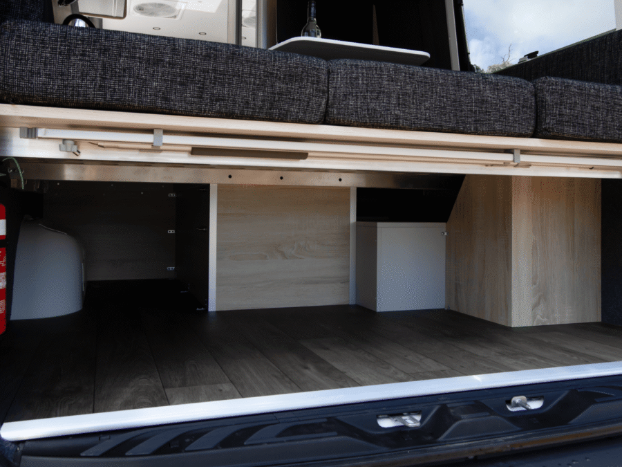 Opbergruimte onder het bed- en zitgedeelte, zichtbaar vanuit de achterzijde van de RedSands Frontier camper met geopende klep