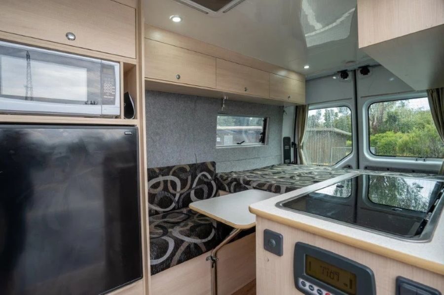 Magnetron, koelkast, aanrecht en zithoek in de Leisure Rent 2 Berth Campervan