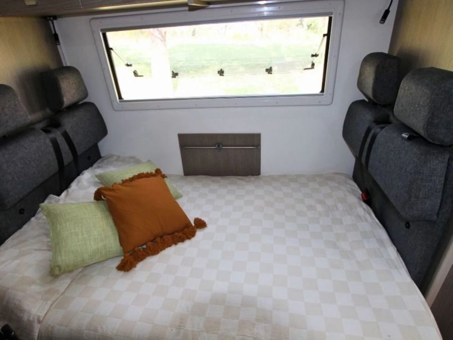 Het bed van de dinette in de Leisure Rent Deluxe Motorhome is opgemaakt