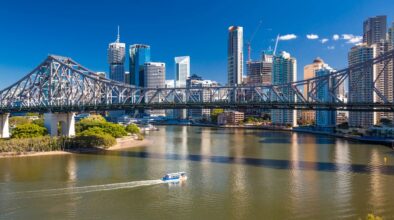 Ferry vaart onder de Story Bridge in Brisbane door met zicht op de skyline