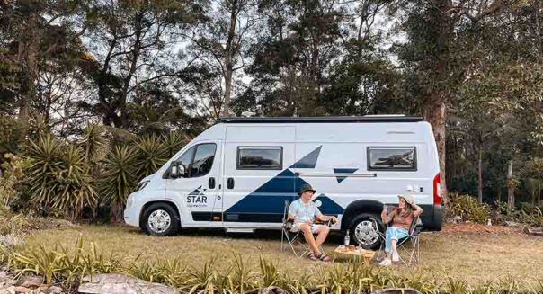 Een stel heeft de Star RV Polaris 2 camper geparkeerd op een kampeerplaats en zit voor de camper