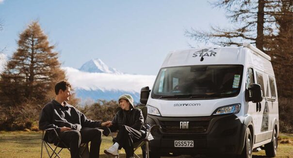 Een koppel zit op de campingstoelen voor de Star RV Polaris 2 camper tijdens het kamperen in Nieuw-Zeeland