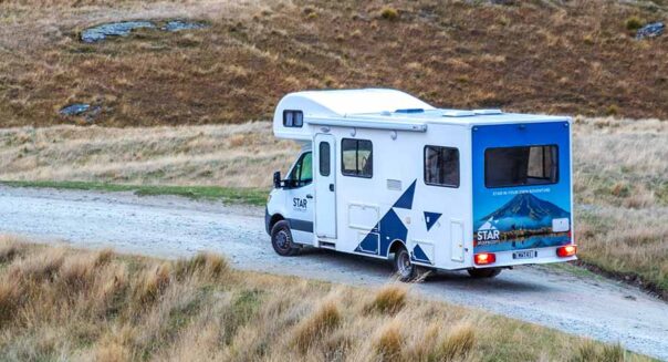 De Star RV Polaris 6 staat geparkeerd op een grindweg in de natuur van Nieuw-Zeeland