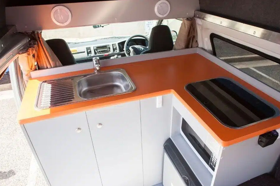 De keuken in de Travellers Autobarn Kuga camper met wasbak, gasfornuis en magnetron