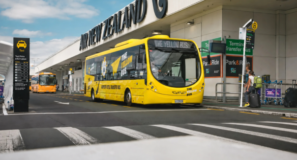 De Yellow Bus staat geparkeerd voor de luchthaven in Auckland