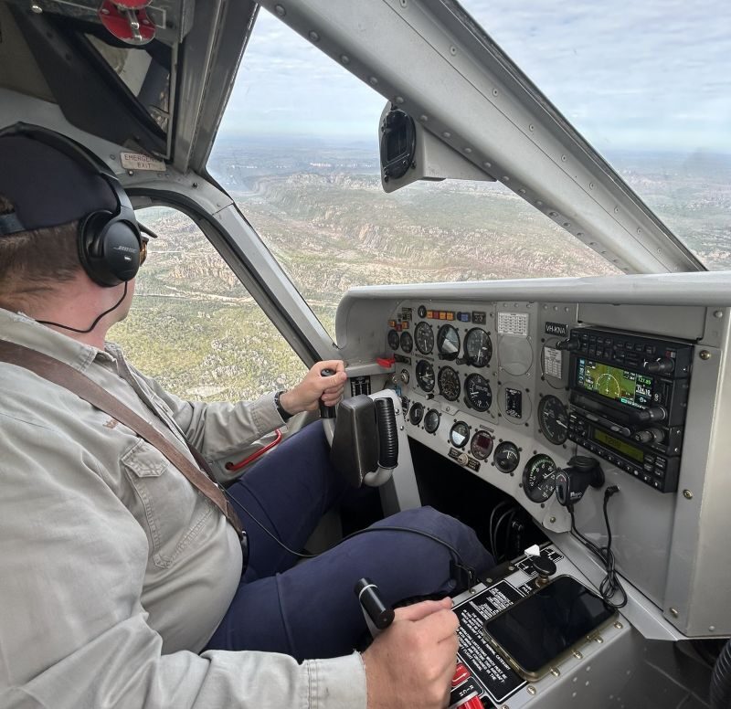 Zicht uit de cockpit langs de piloot tijdens de vlucht in Kakadu