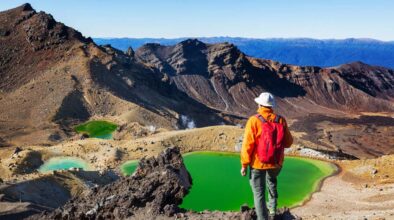 Een man kijkt naar de Emerald Lakes tijdens de Tongariro Crossing Track