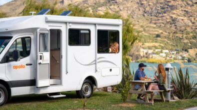 Gezin kampeert met een Apollo camper in Queenstown, kinderen hangen uit het raam