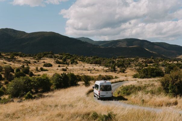 Een Mighty camper rijdt over een weg bij Takaka Hill in Nieuw-Zeeland