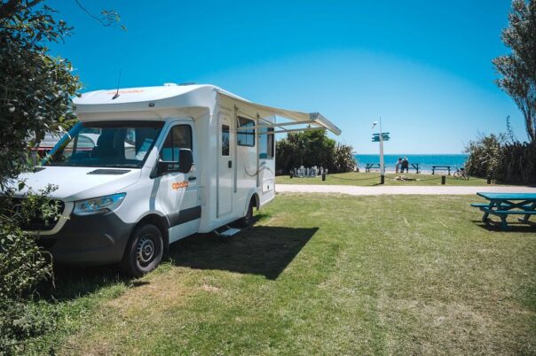 De Apollo Euro Quest camper staat geparkeerd op een camping bij zee in de Golden Bay
