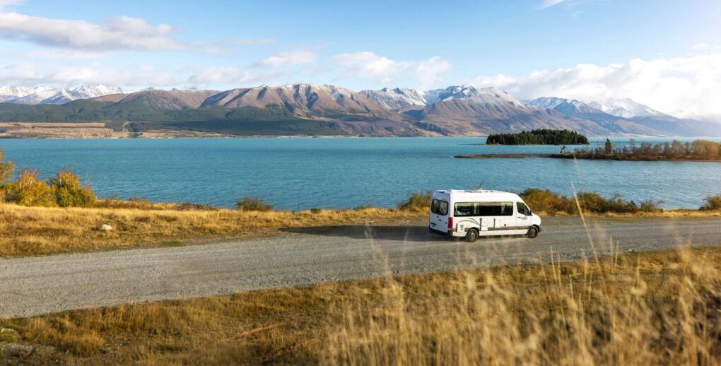 De Maui Ultima rijdt over een weg langs Lake Wanaka met uitzicht op de bergen