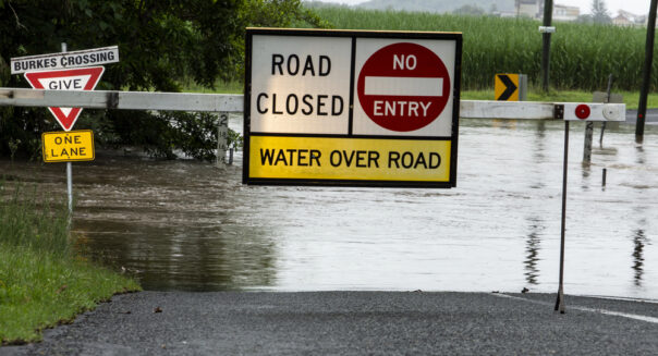 Bord dat aangeeft dat de weg is afgesloten doordat deze overstroomd is door regen